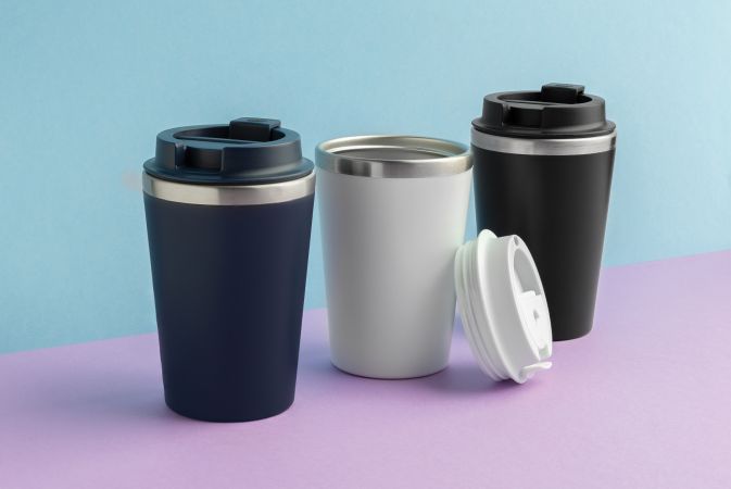 drei Trinkbecher werden auf einem farbigen Hintergrund präsentiert