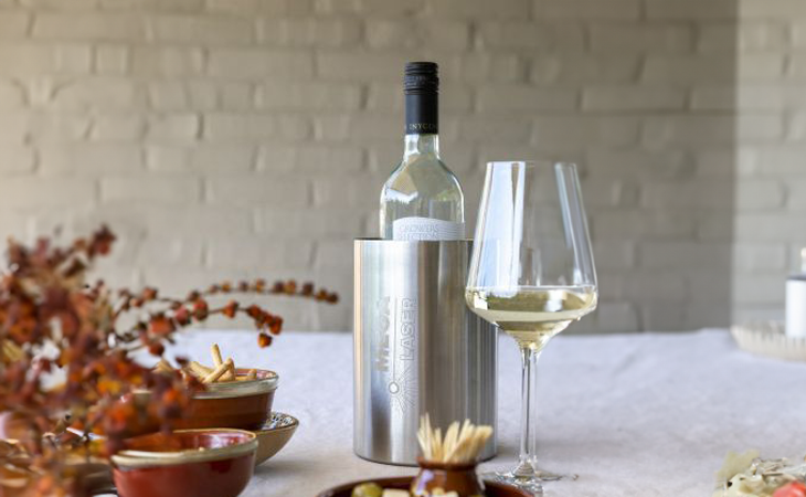 Flaschenkühler aus Edelstahl mit Logo und Weiswein-Flasche auf dem Tisch