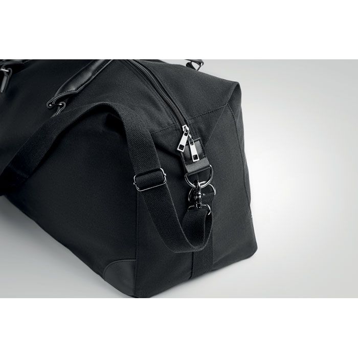 Schwarze Reisetasche mit Schultergurt und Tragegriffe.