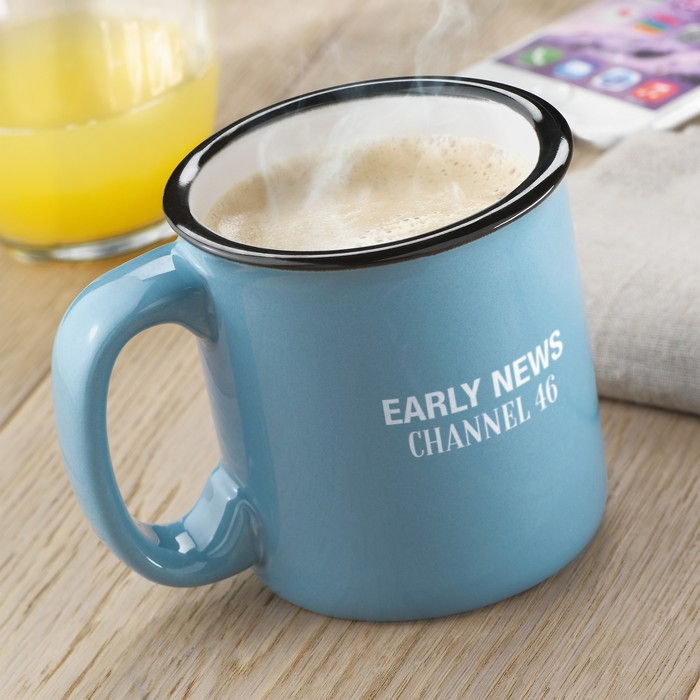 Auf einem Tisch steht eine Blaue Tasse mit weißem Keramiktransferdruck