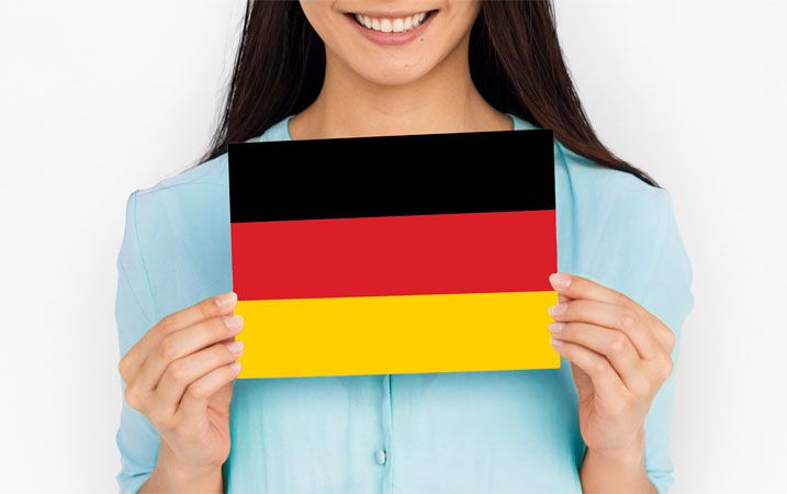 Eine Frau hält eine Deutschlandflagge in die Kamera