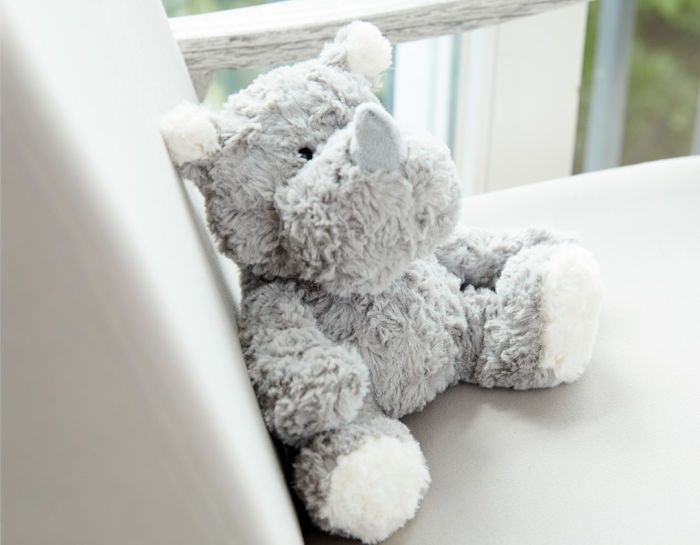 Graues Nilpferd Kuscheltier auf dem Sofa.