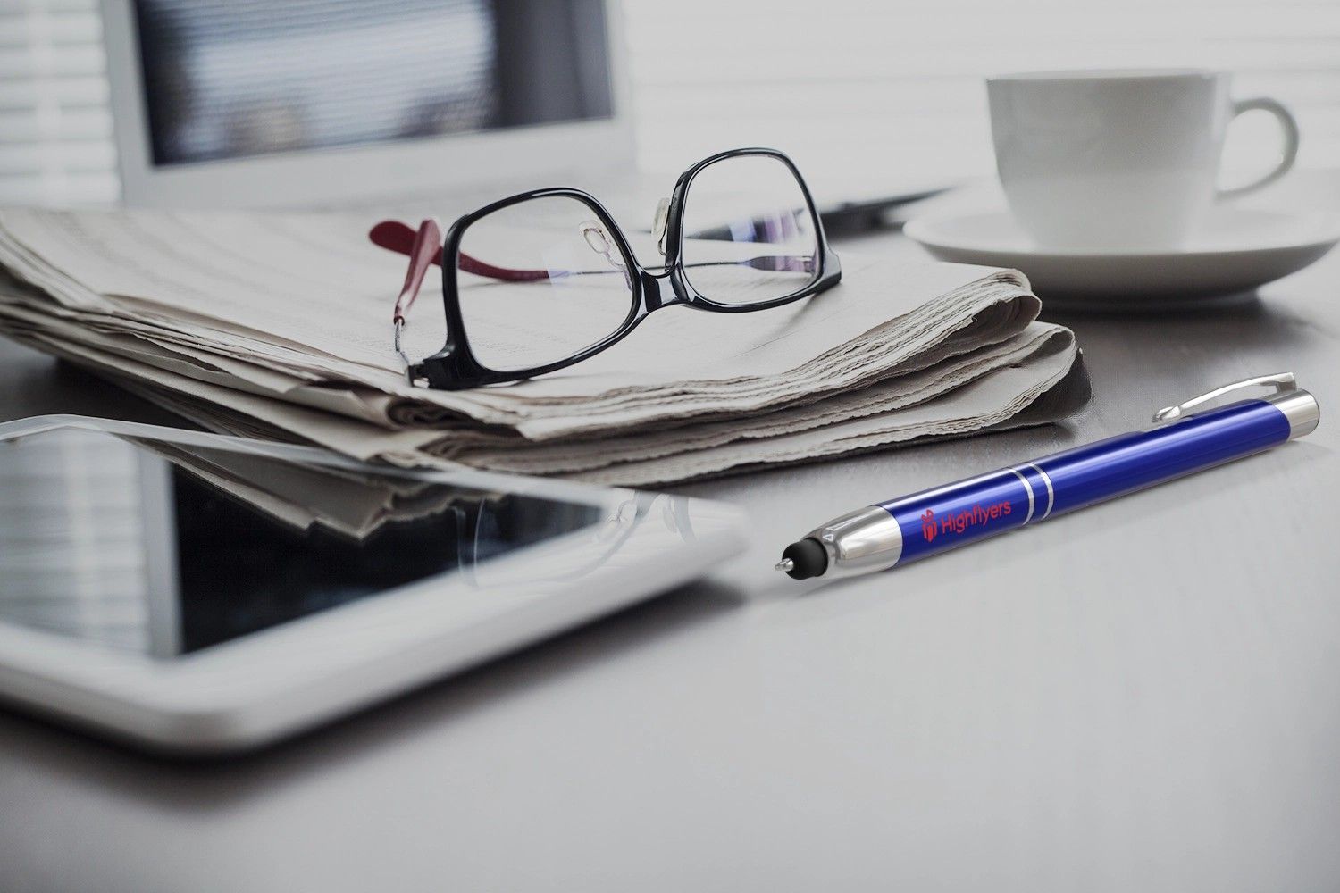 blauer Touchpen mit Logo auf Schreibtisch mit Brille