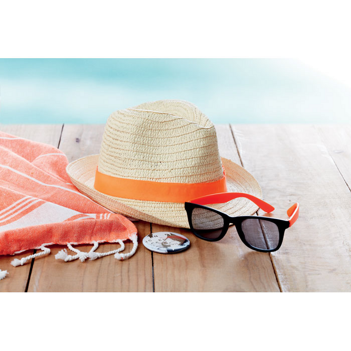 Ein Strandtuch, ein Strohhut und eine Sonnenbrille liegen in der Sonne. Das sind perfekte Werbegeschenke für Ihre Kunden.