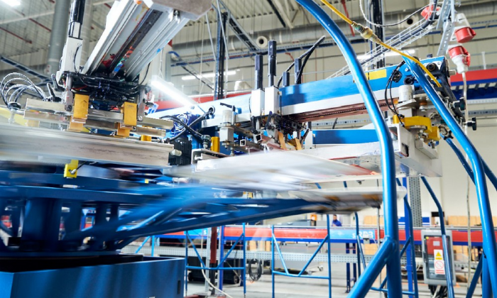 Eine moderne Siebdruck Maschine mit Karussell Arm ist im Einsatz.