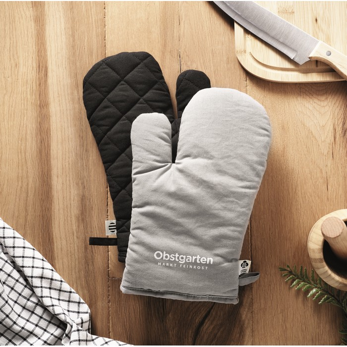 Zwei Topflappen liegen in der Küche. Der Stoff der Topfhandschuhe ist mit einem Siebdruck veredelt.