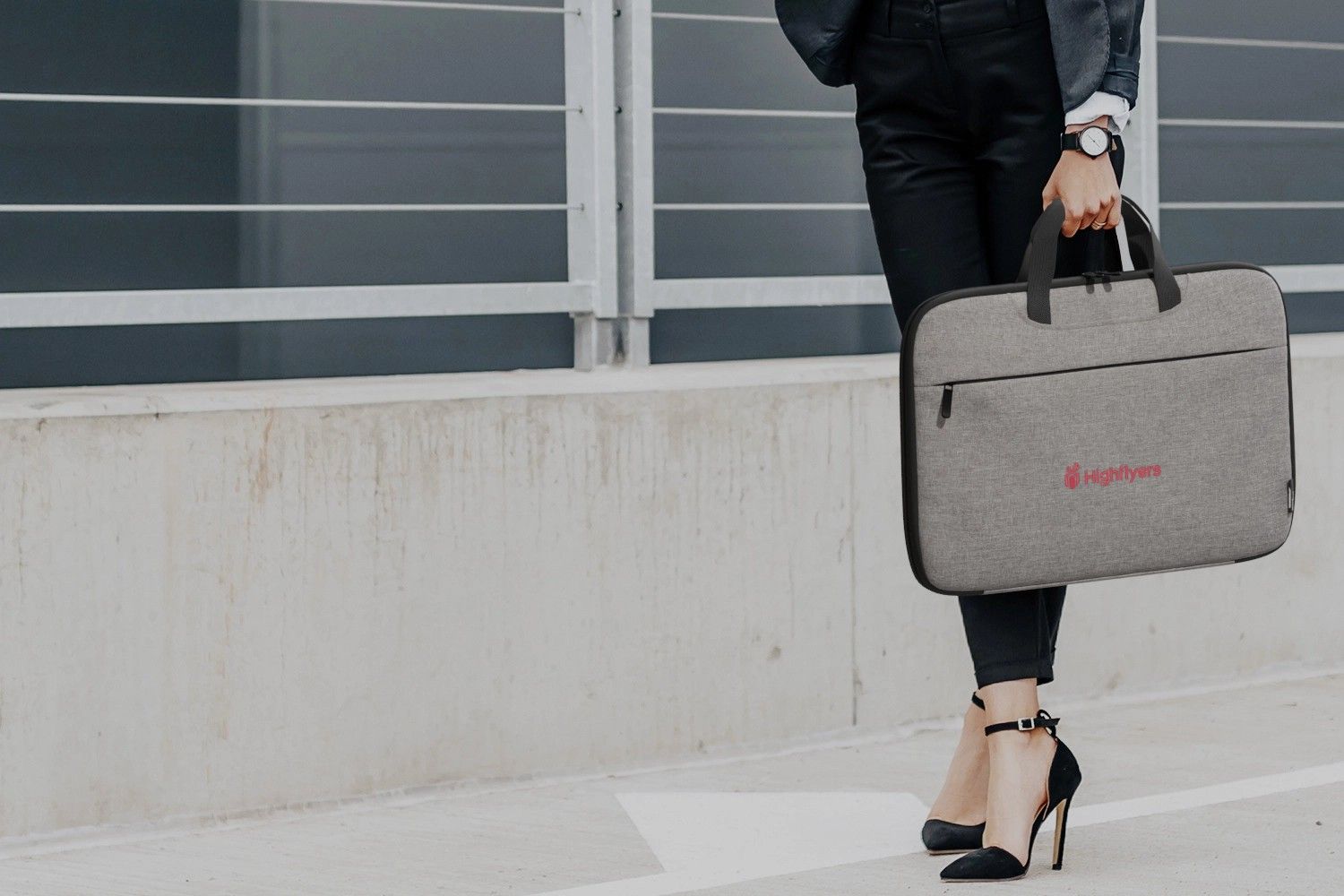 graue Laptoptasche wir von stehender Person gehalten