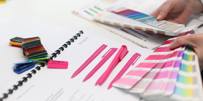 Mit einem Pantone Farbfächer wird die Kugelschreiber Farbe auf Übereinstimmung geprüft.