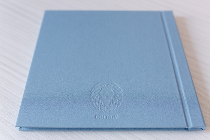 zu sehen ist ein blaues Notizbuch mit Prägung