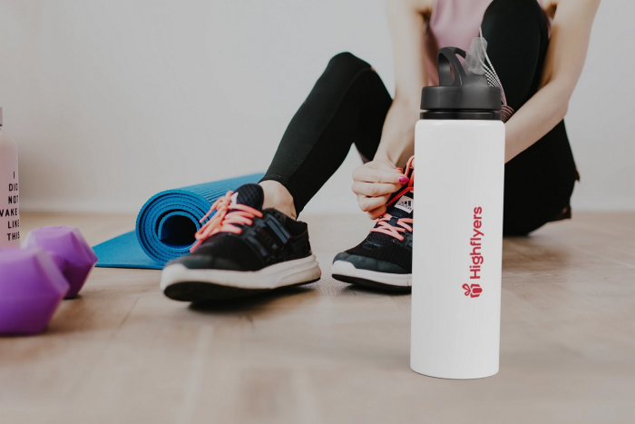 Eine weiße Sporttrinkflasche mit Highflyers Logo bedruckt wird für den Sport verwendet.