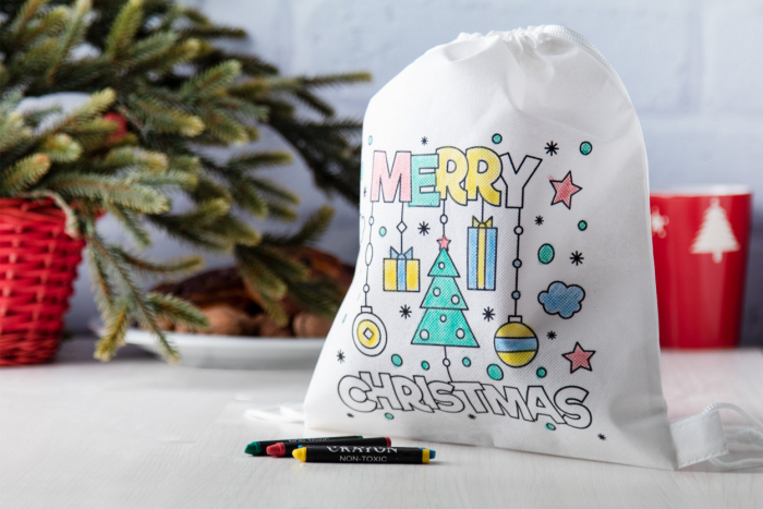 Ein weißer Beutel mit einem vorgedruckten, weihnachtlichen Motiv kann selbst bemalt werden.