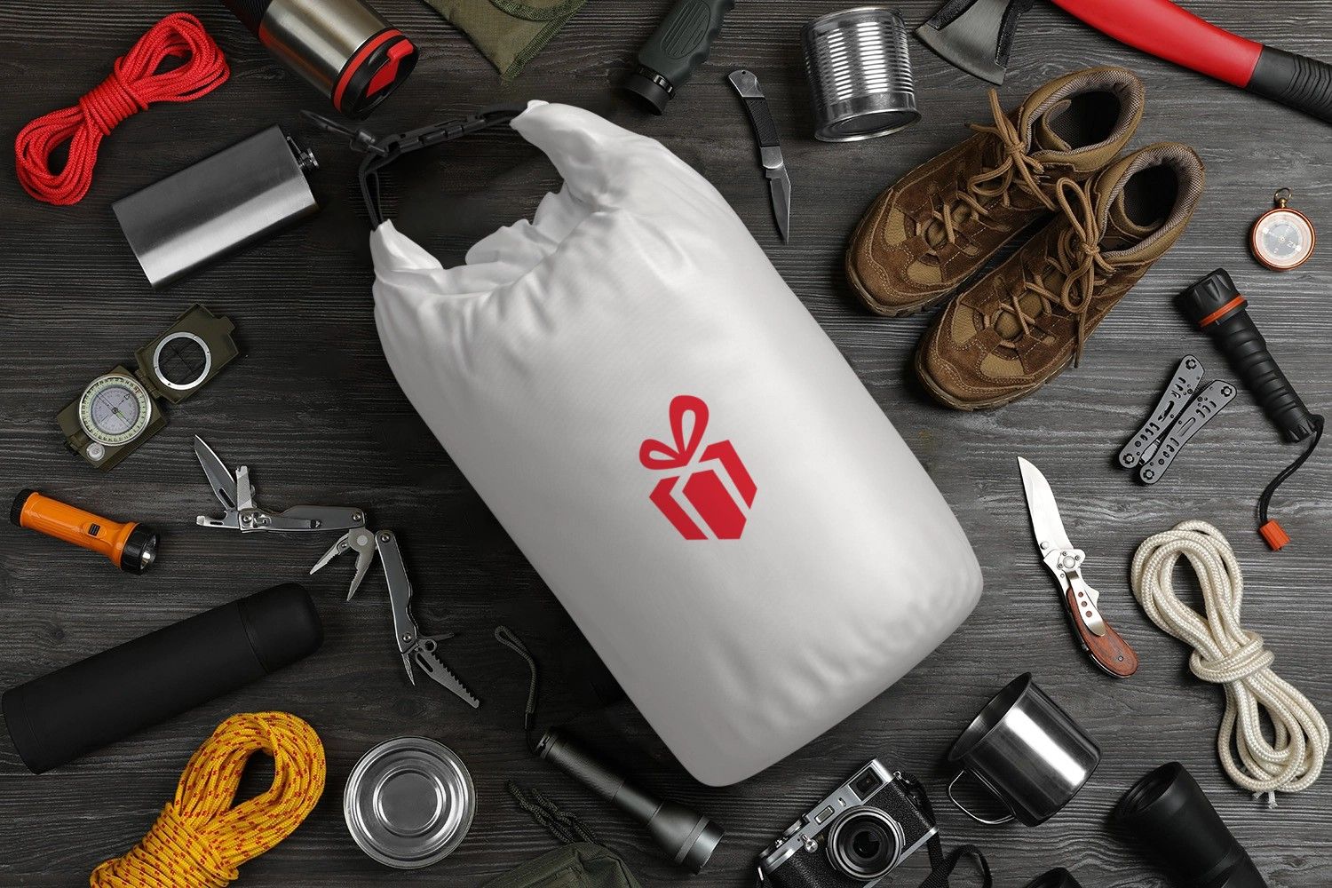 weißer Seesack mit Logo auf Tisch mit vielen anderen Artikeln zum Campen