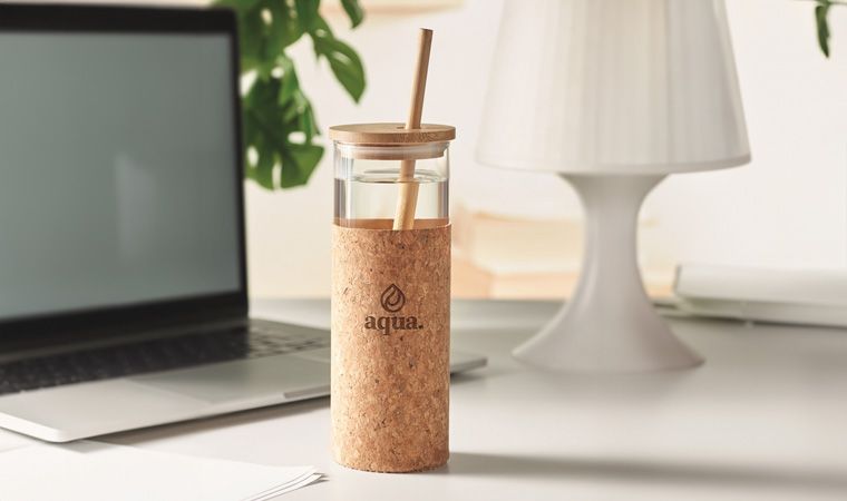 Zylinderförmiges Glas mit Bambushalm auf dem Schreibtisch